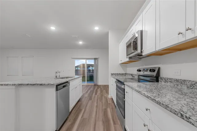 a kitchen with granite countertop cabinets stainless steel appliances and a counter space