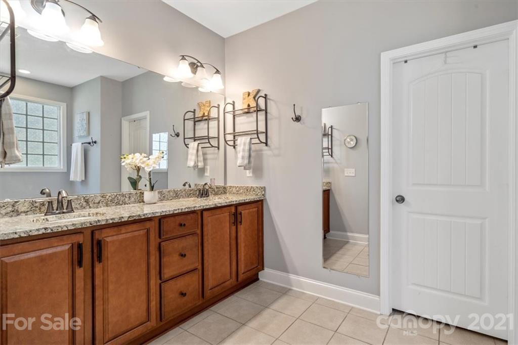 79067 Ridgehaven Road Lancaster, SC 29720 - Photo 18 of 38 a bathroom with a granite countertop sink two mirror and a shower
