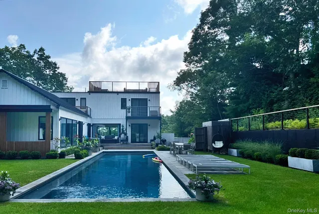 a view of a house with swimming pool and sitting area