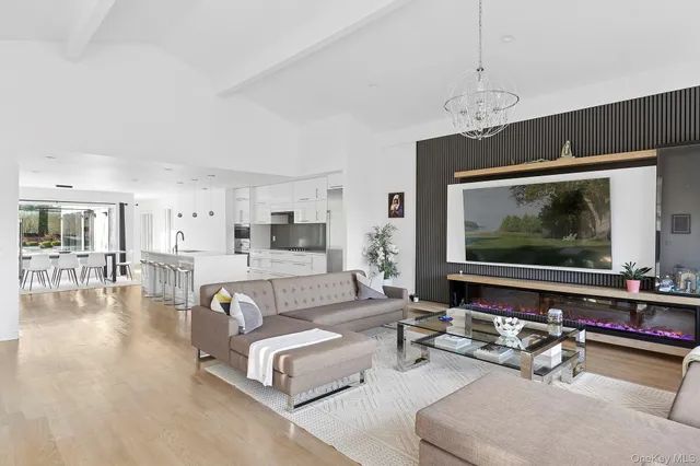 a living room with furniture a chandelier and a flat screen tv