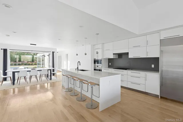 a kitchen with white cabinets and chairs