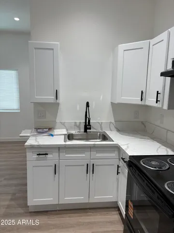 a kitchen with a sink stove and cabinets