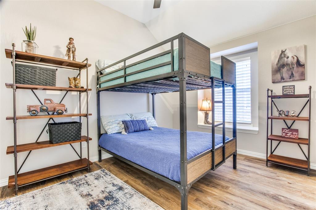 8060 Watson Road Lantana, TX 76226 - Photo 10 of 16 a bedroom with a bed a rug and wooden floor