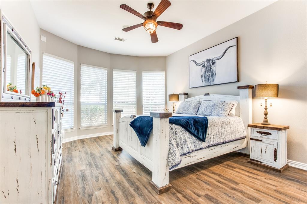 8060 Watson Road Lantana, TX 76226 - Photo 12 of 16 a bedroom with a bed and wooden floor