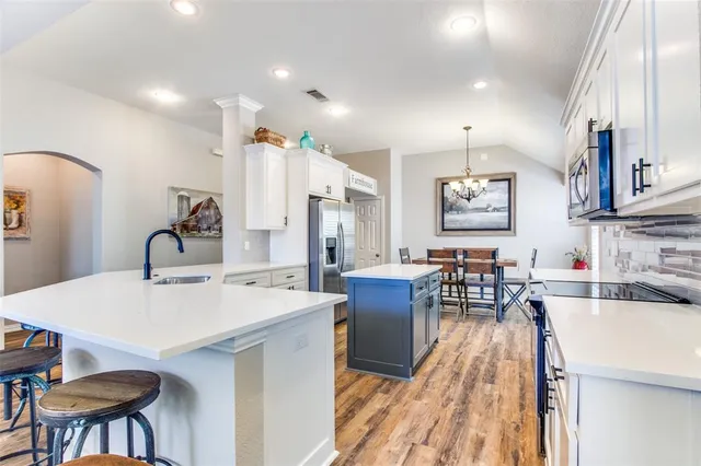a large kitchen with stainless steel appliances lots of counter space and a sink