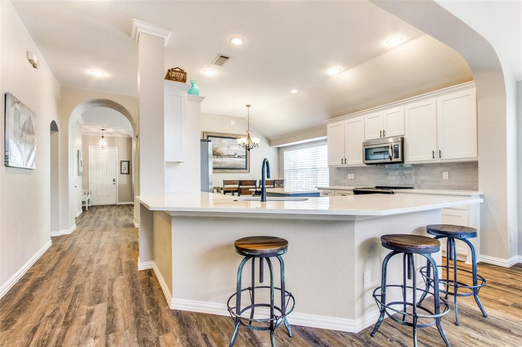 8060 Watson Road Lantana, TX 76226 - Photo 8 of 16 a kitchen with stainless steel appliances a dining table chairs microwave and cabinets