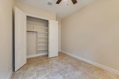 an empty room with closet and windows