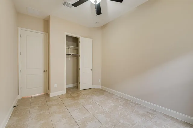 an empty room with a ceiling fan and entryway