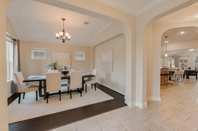 a view of a dining room and livingroom with furniture wooden floor a chandelier