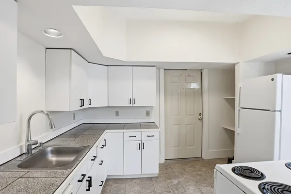 a kitchen with a sink cabinets and refrigerator