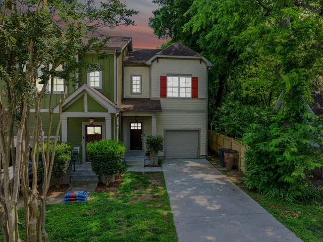 a front view of a house with a yard and trees