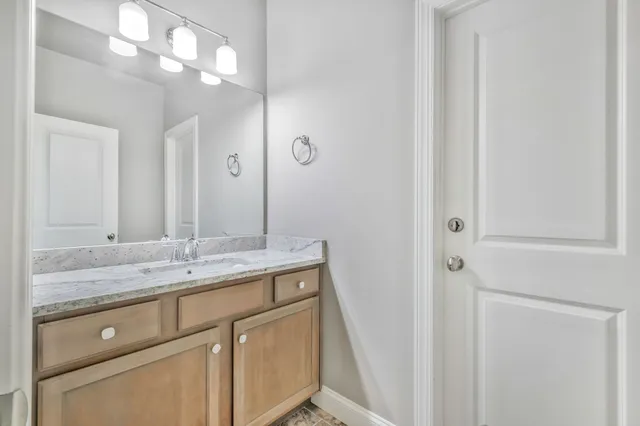 a bathroom with a toilet a sink a mirror and a window