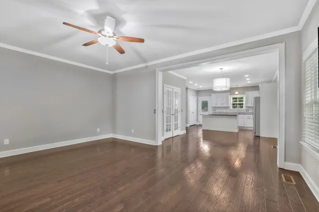 a view of a kitchen with refrigerator and wooden floor