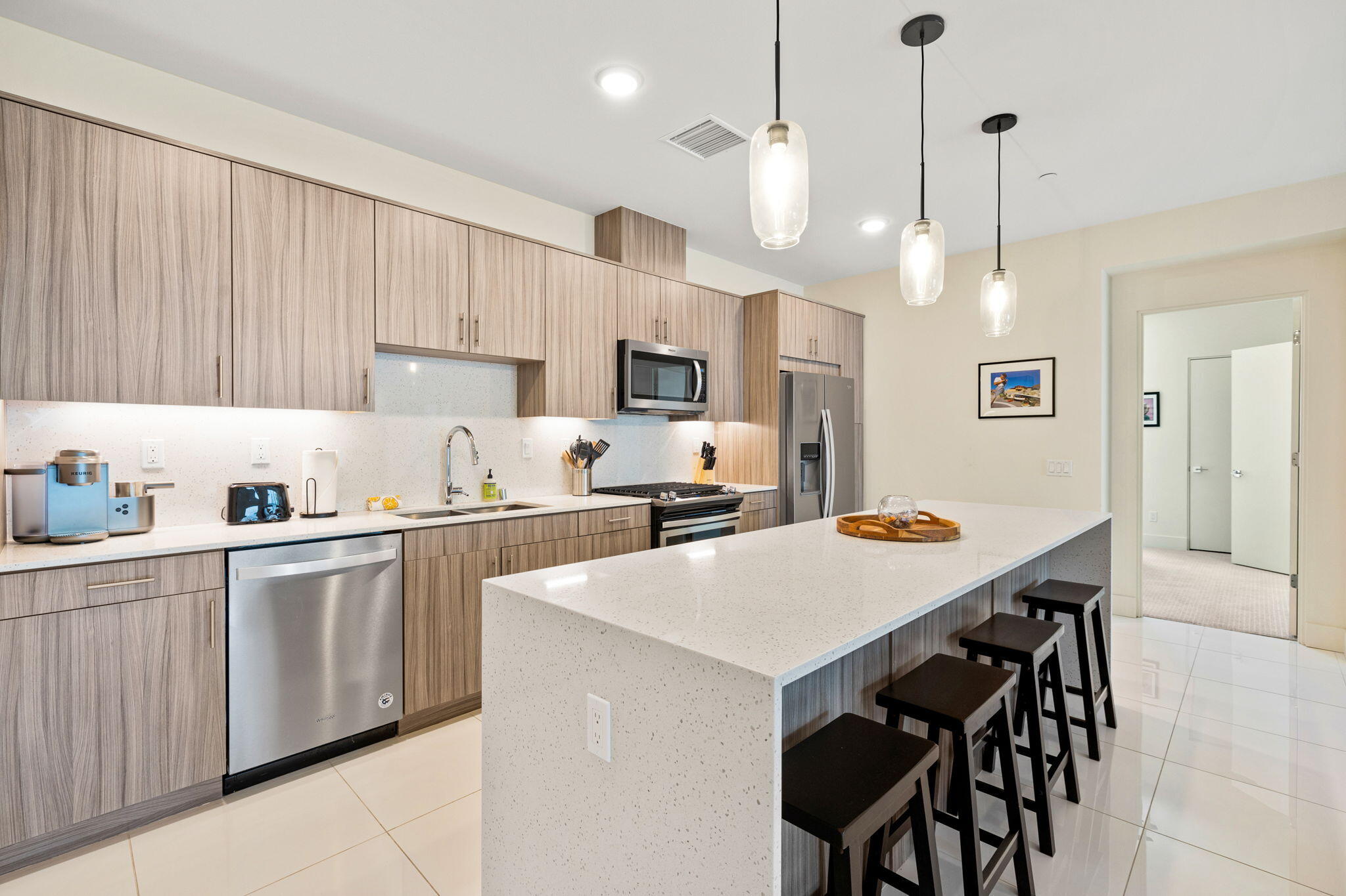 191 The River Palm Springs, CA 92262 - Photo 13 of 39 a kitchen with a table chairs refrigerator and microwave