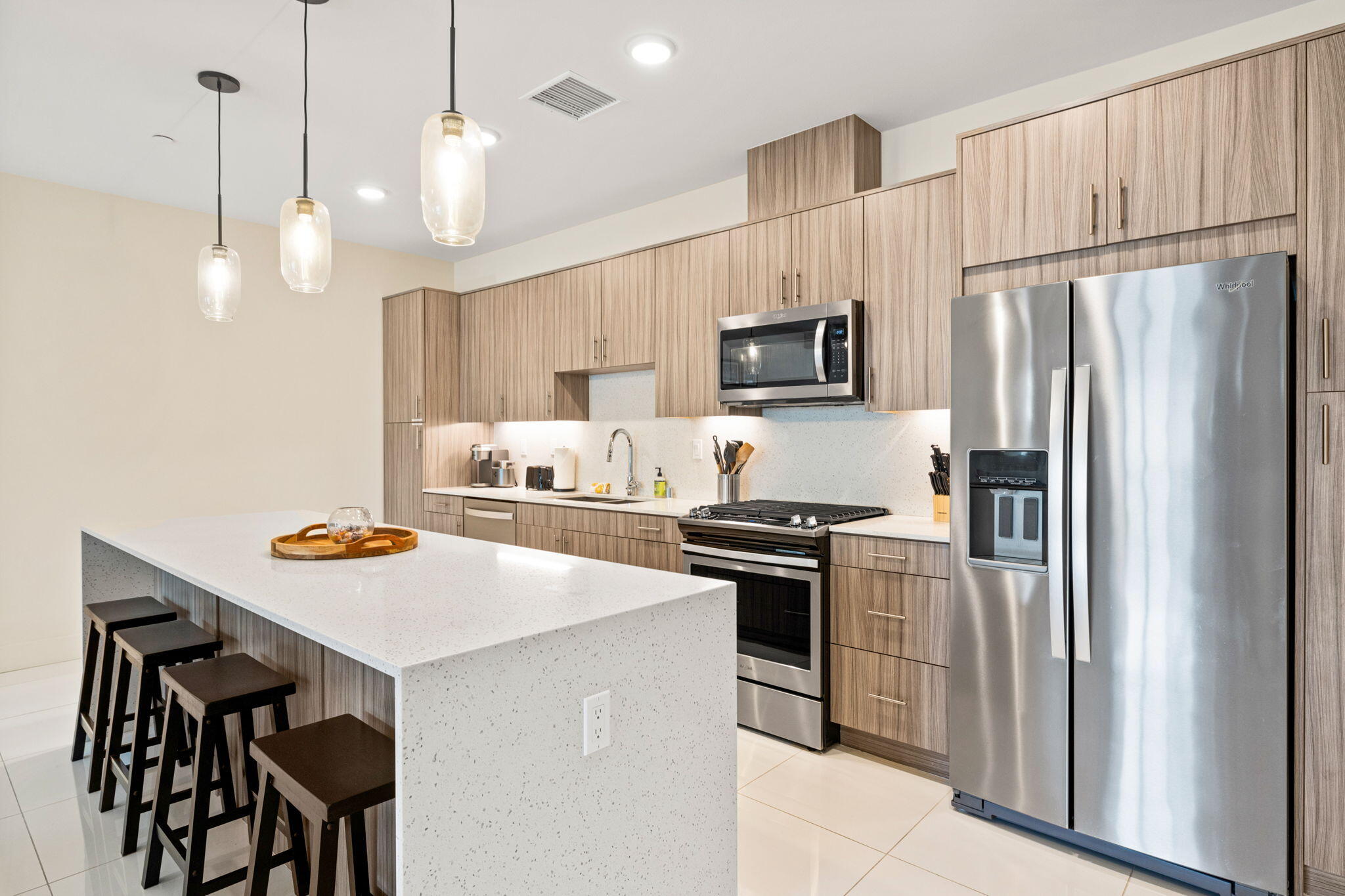 191 The River Palm Springs, CA 92262 - Photo 9 of 39 a kitchen with stainless steel appliances a stove a sink a refrigerator a center island a table and chairs
