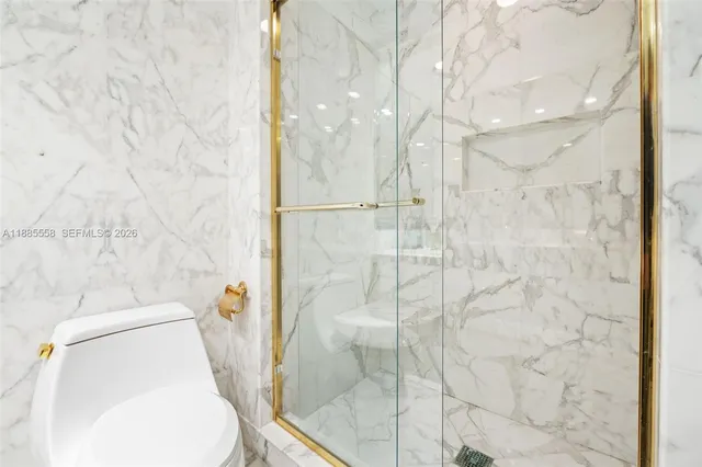 a bathroom with a granite countertop sink mirror vanity and toilet