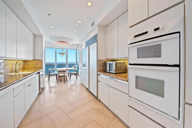 a kitchen with stainless steel appliances white cabinets and wooden floor