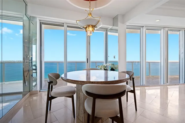 a dining room with furniture and a floor to ceiling window