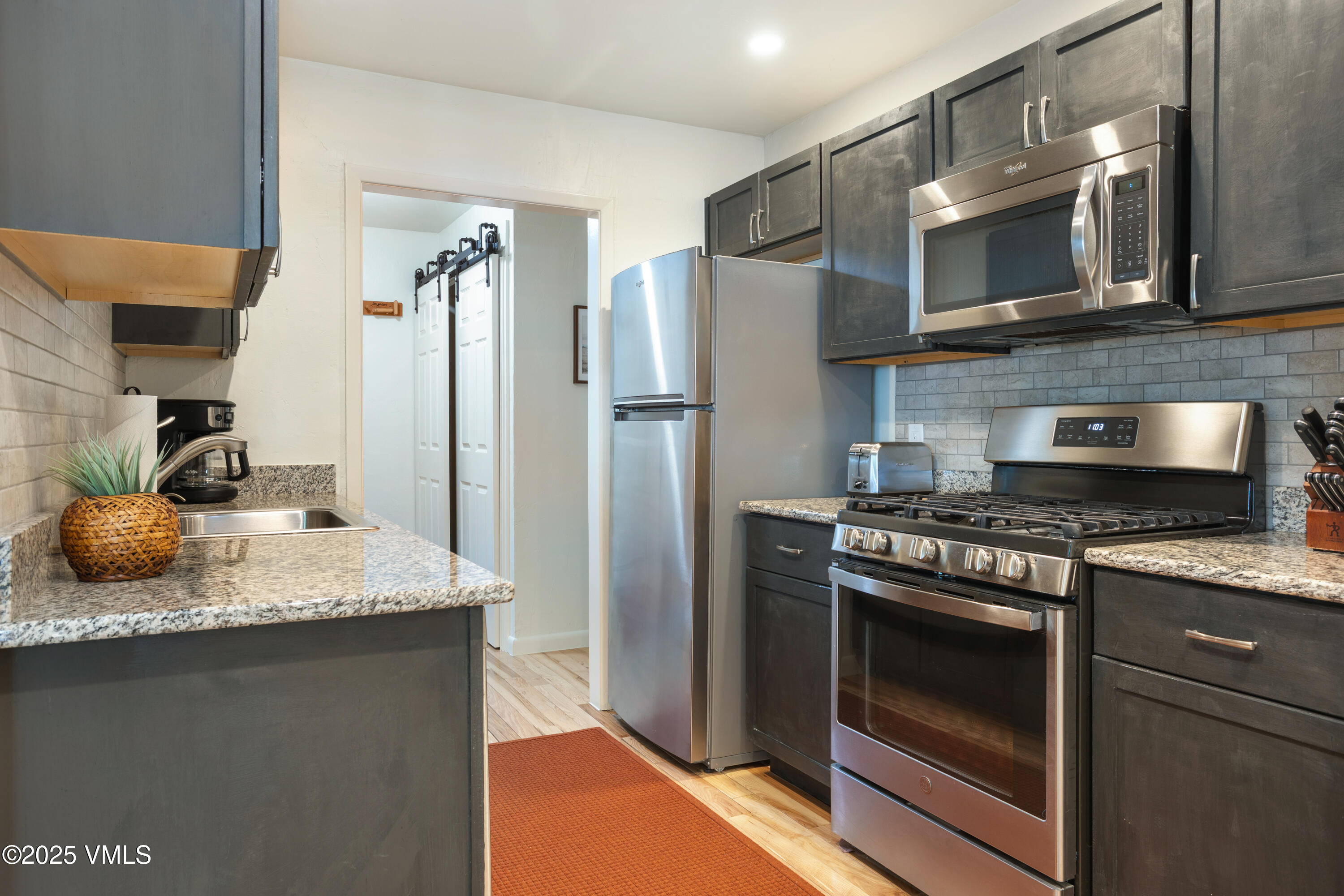 909 Red Sandstone Road, Unit B2 Vail, CO 81657 - Photo 11 of 24 a kitchen with stainless steel appliances granite countertop a stove microwave and refrigerator
