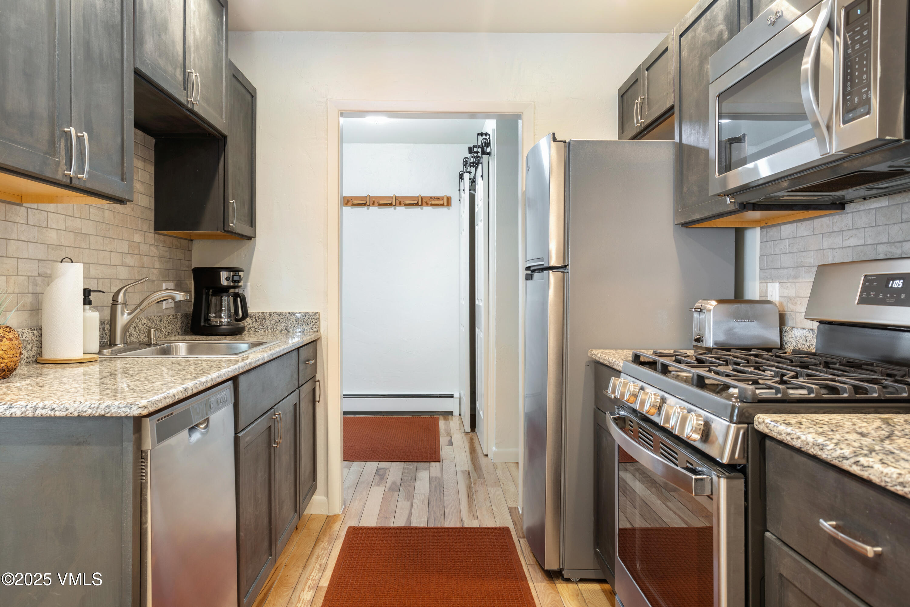 909 Red Sandstone Road, Unit B2 Vail, CO 81657 - Photo 3 of 24 a kitchen with stainless steel appliances granite countertop a refrigerator stove and sink