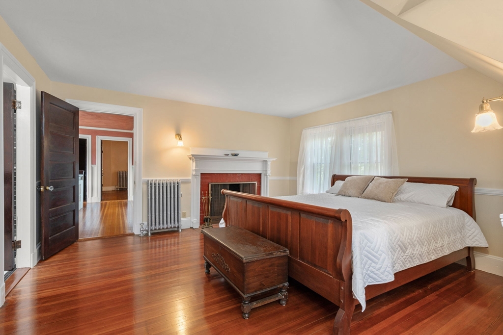 570 Washington Street Dedham, MA 02026 - Photo 25 of 37 a bedroom with a bed and a fireplace