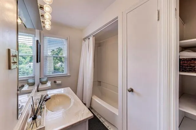 a en suite bathroom with a granite countertop sink a mirror and a shower