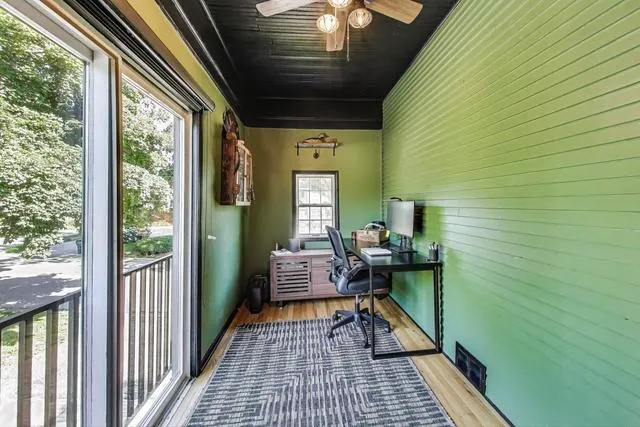 a balcony with chairs and a potted plant