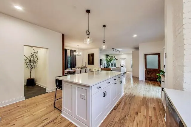 a large kitchen with kitchen island a wooden floor