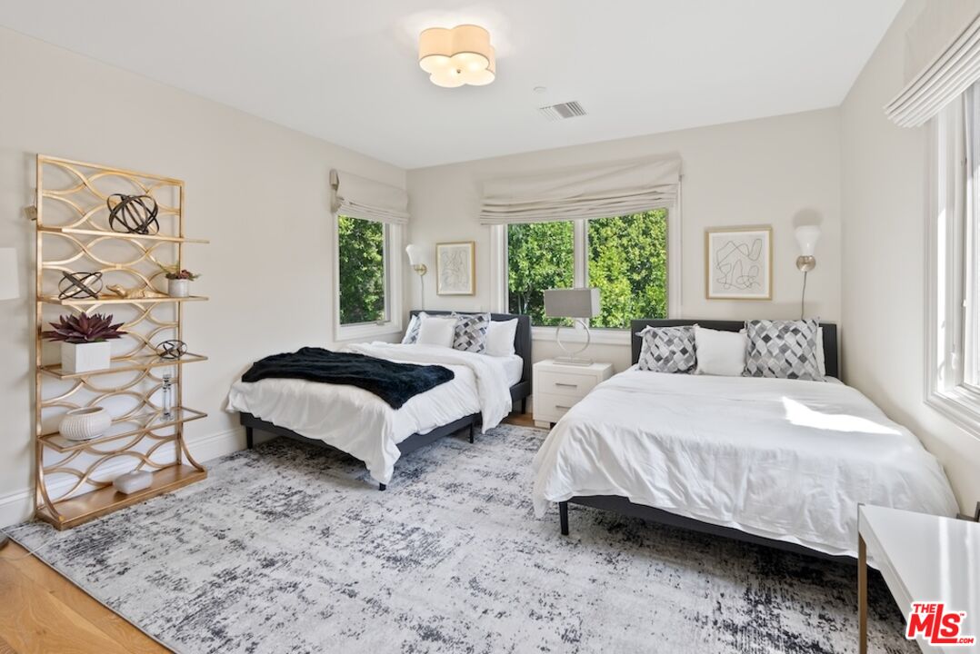 23593 Parksouth Street Calabasas, CA 91302 - Photo 54 of 75 a spacious bedroom with a bed lamp and a large window