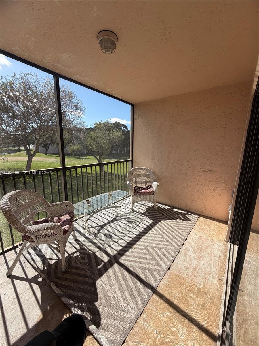 10360 Northwest 30th Court, Unit 204 Sunrise, FL 33322 - Photo 17 of 24 a view of a balcony with two chairs and a table