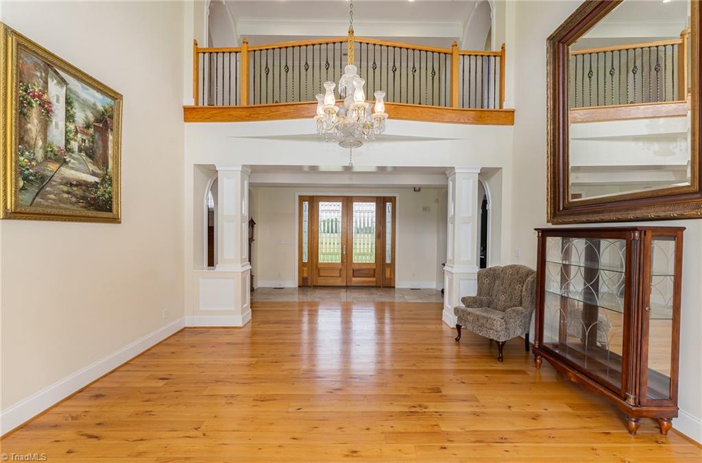 2250 Bethel Church Road Pleasant Garden, NC 27313 - Photo 19 of 45 Spacious living room with soaring ceilings and elegant custom columns, visible directly from the front door, creating an impressive and welcoming atmosphere