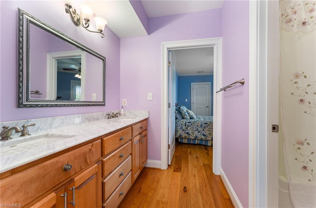 2250 Bethel Church Road Pleasant Garden, NC 27313 - Photo 29 of 45 Jack and Jill bathroom connecting the third and fourth bedrooms, featuring a walk-in closet, shower, dual sinks, and ample storage.