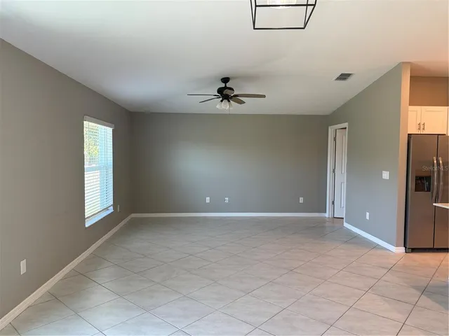 an empty room with fan and windows