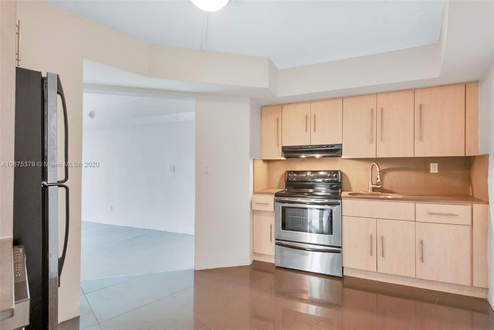 Morningside Miami, FL 33137 - Photo 10 of 27 a kitchen with stainless steel appliances granite countertop a refrigerator and white cabinets