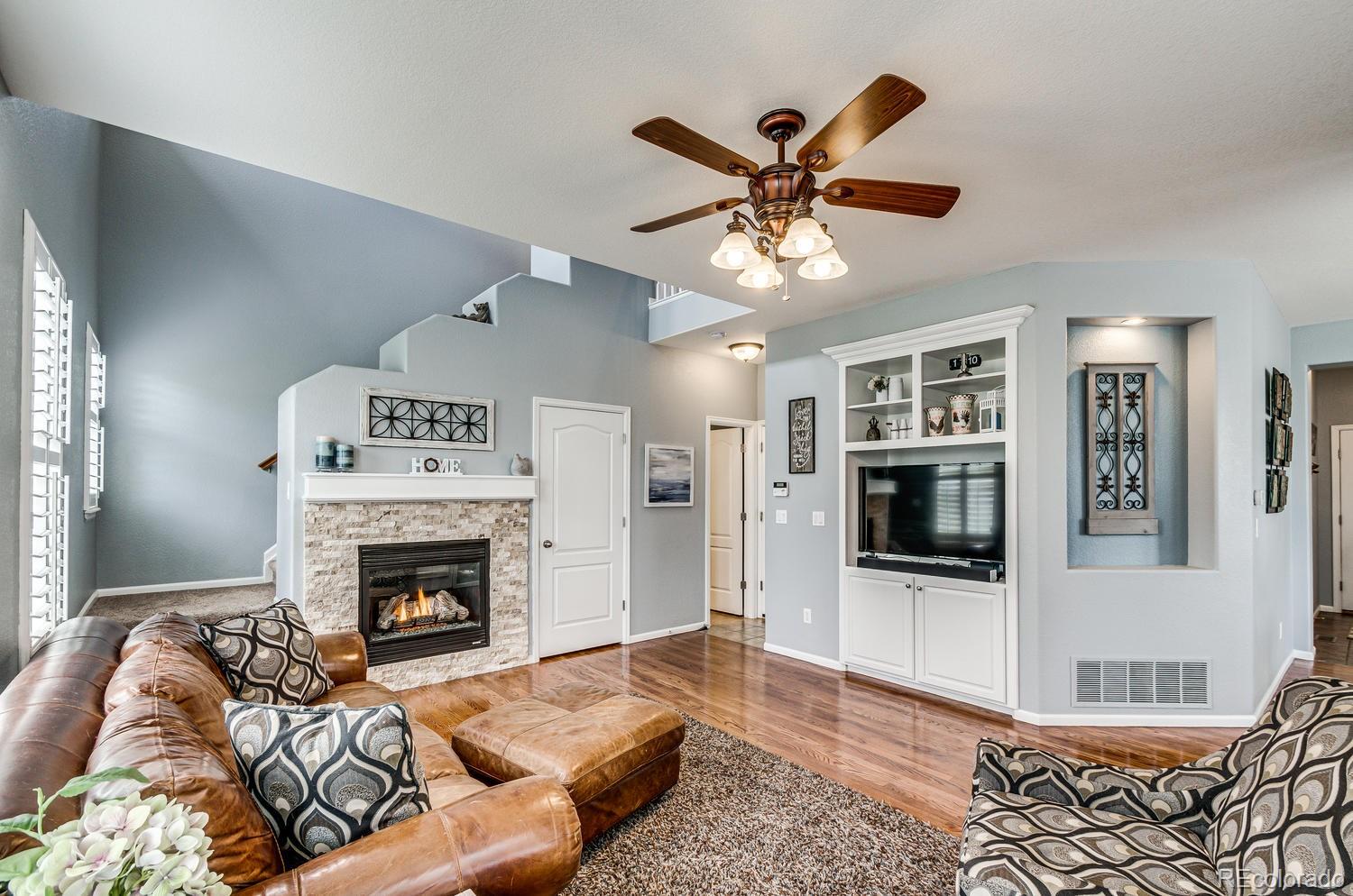 10864 Brooklawn Road Highlands Ranch, CO 80130 - Photo 2 of 28 a living room with furniture and a fireplace