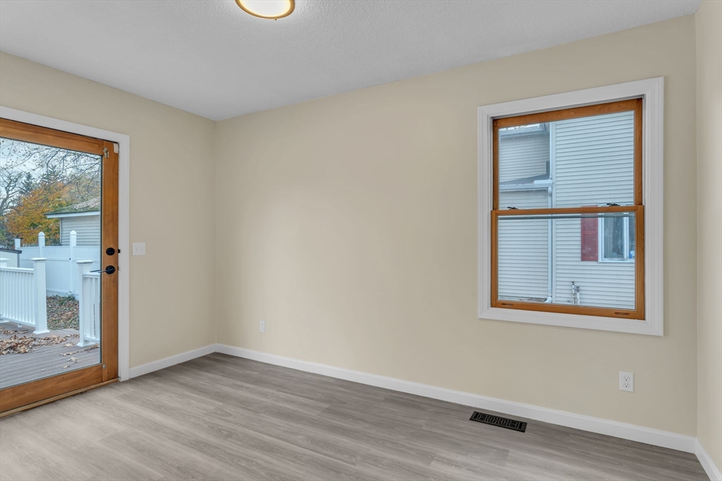 115 Carroll Street Springfield, MA 01108 - Photo 16 of 25 a view of an empty room with wooden floor and a window