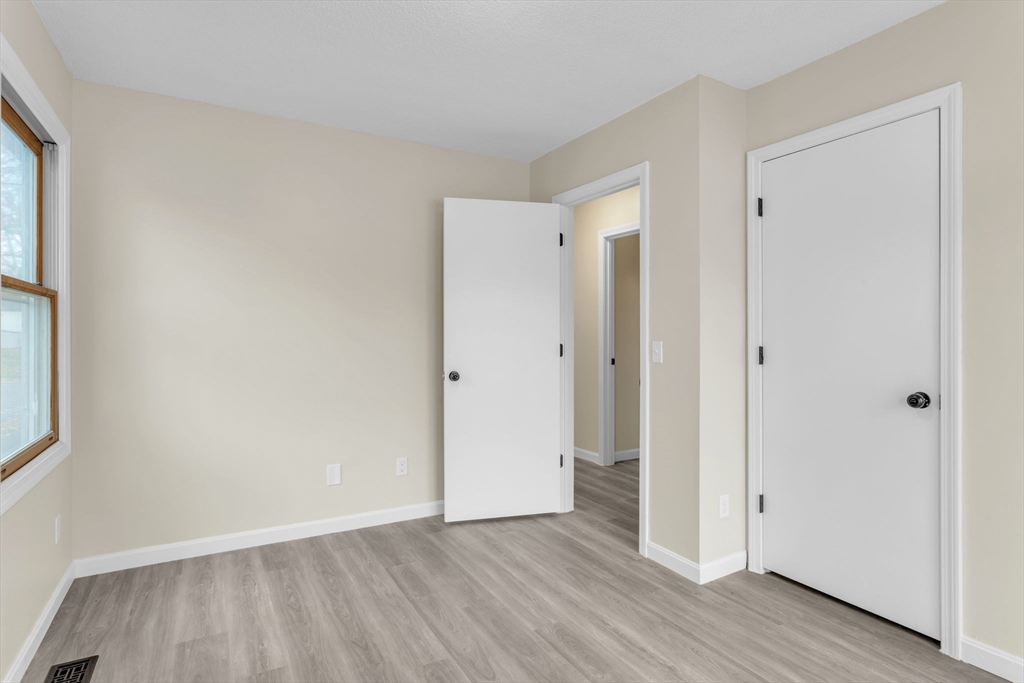 115 Carroll Street Springfield, MA 01108 - Photo 18 of 25 a view of an empty room with wooden floor and a window