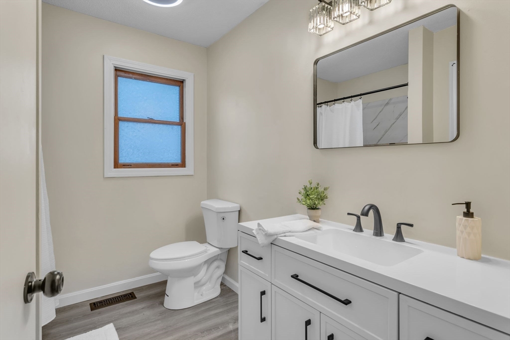 115 Carroll Street Springfield, MA 01108 - Photo 19 of 25 a bathroom with a toilet a sink and mirror