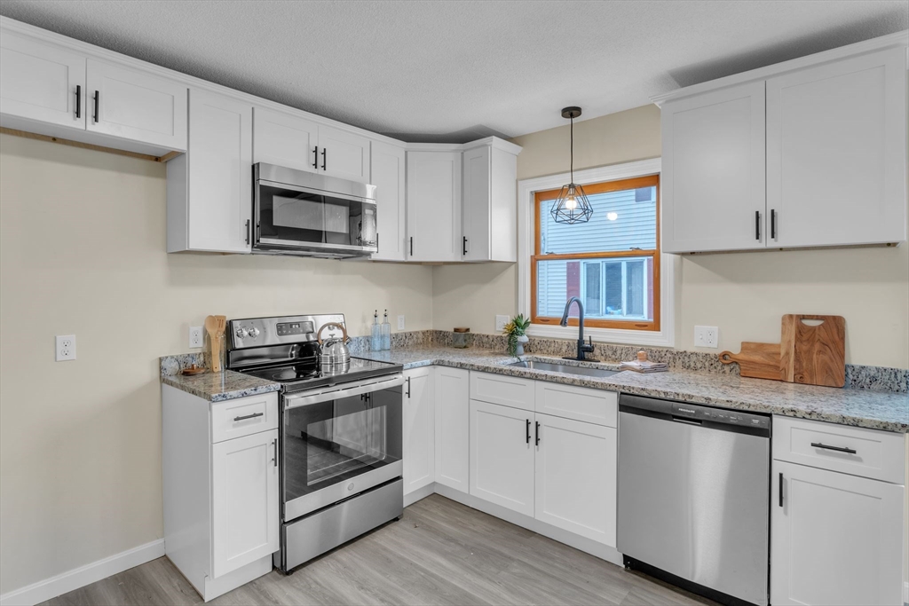 115 Carroll Street Springfield, MA 01108 - Photo 10 of 25 a kitchen with white cabinets stainless steel appliances and sink
