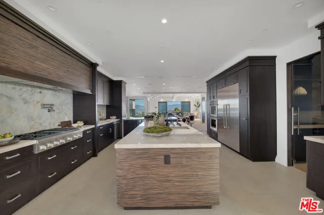 a kitchen with a refrigerator and a stove top oven