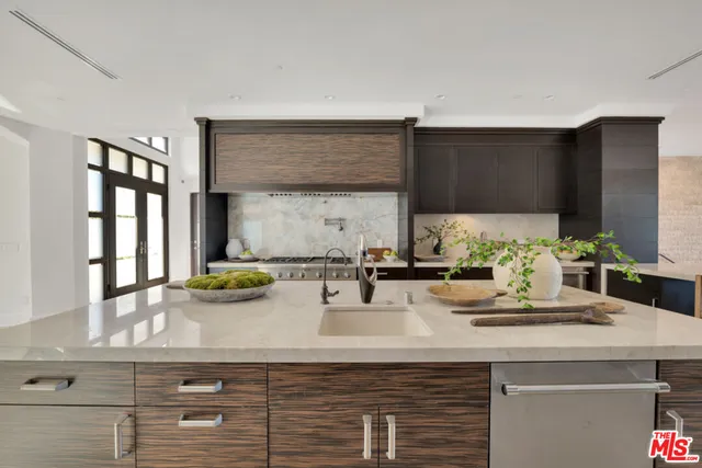 a kitchen with stainless steel appliances kitchen island granite countertop a sink and cabinets