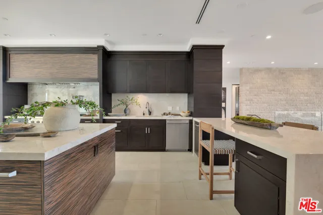 a kitchen with stainless steel appliances kitchen island granite countertop a refrigerator oven a sink dishwasher and a stove with the view