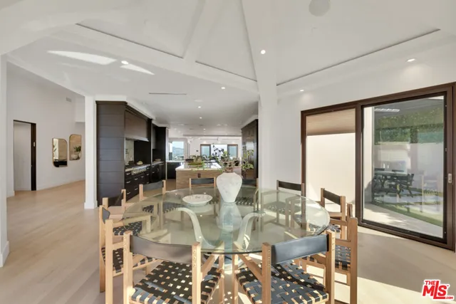 a large kitchen with kitchen island a counter top space a sink and stainless steel appliances