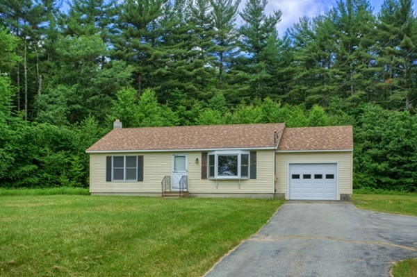 16 Clement Road Townsend, MA 01474 - Photo 1 of 19 a view of a yard in front of a house with plants and large tree