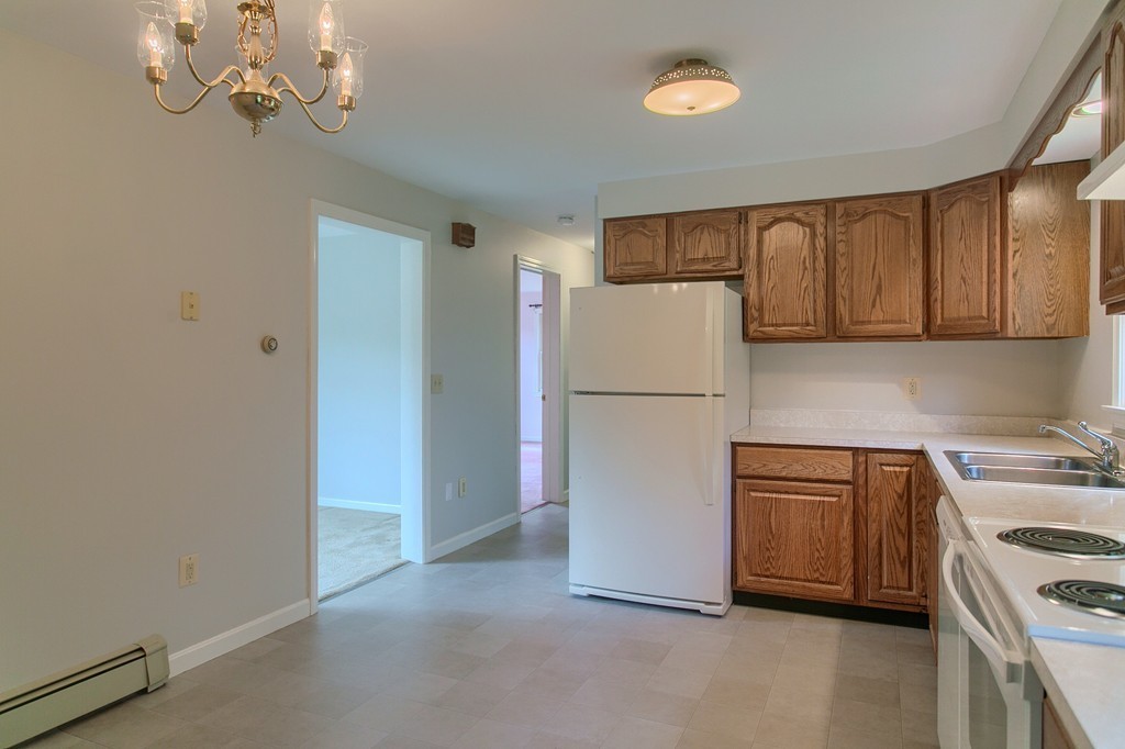 16 Clement Road Townsend, MA 01474 - Photo 4 of 19 a kitchen with refrigerator a stove a microwave and cabinets