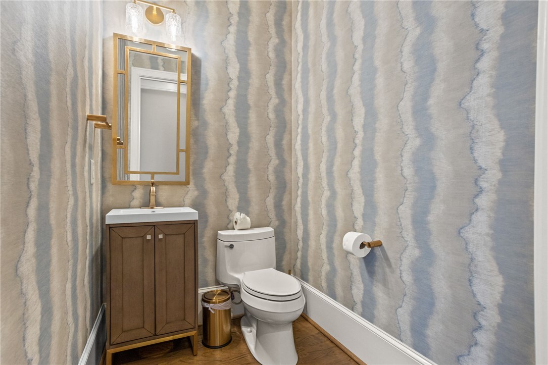 314 Palmer Way Sunset, SC 29685 - Photo 14 of 48 A striking powder room features elegant wallpaper, a modern vanity, and lustrous gold fixtures.