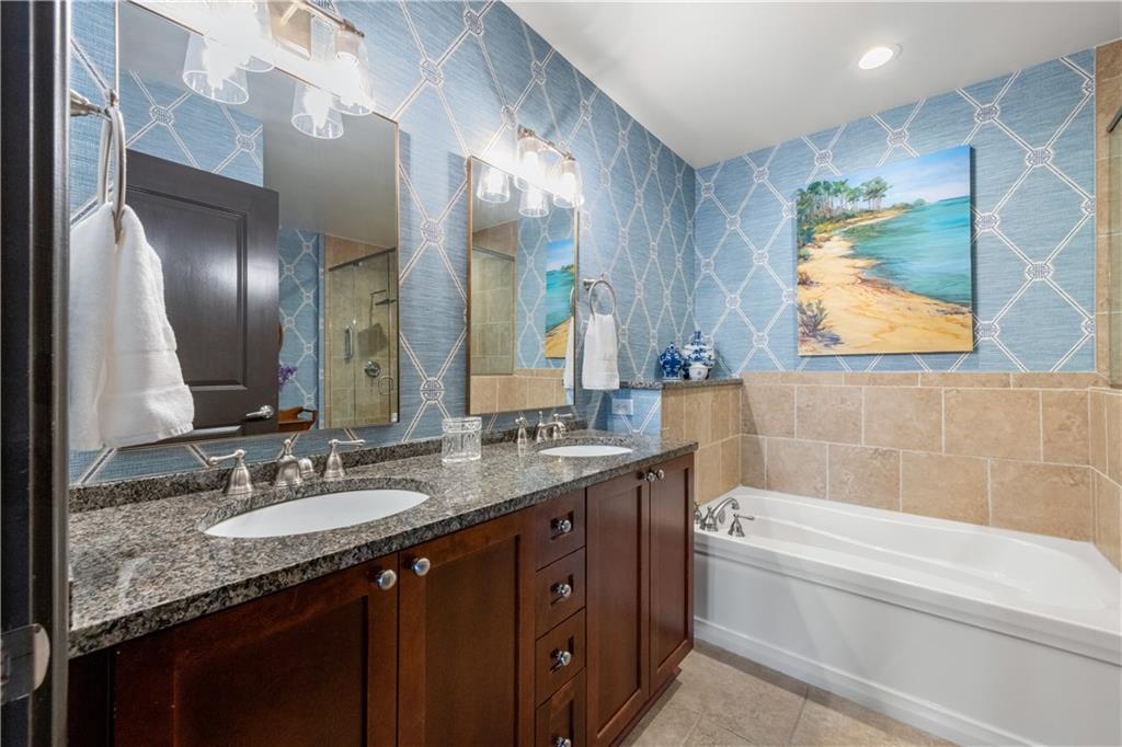201 West Ponce De Leon Avenue, Unit 502 Decatur, GA 30030 - Photo 33 of 49 a bathroom with a granite countertop bathtub sink vanity and mirror
