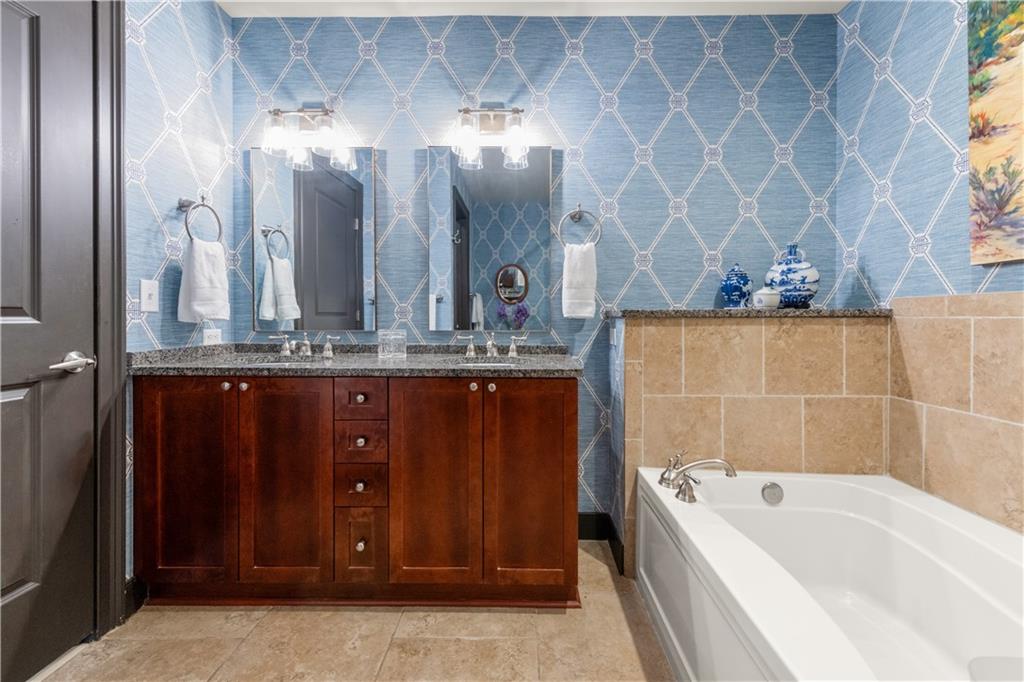 201 West Ponce De Leon Avenue, Unit 502 Decatur, GA 30030 - Photo 36 of 49 a bathroom with a tub a double vanity sink and a mirror