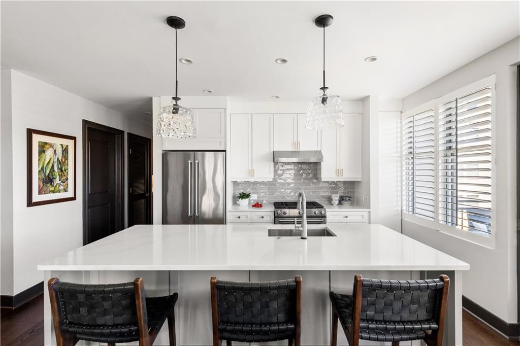 201 West Ponce De Leon Avenue, Unit 502 Decatur, GA 30030 - Photo 5 of 49 a kitchen with stainless steel appliances a dining table chairs and refrigerator