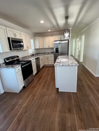 a kitchen with stove a sink and refrigerator